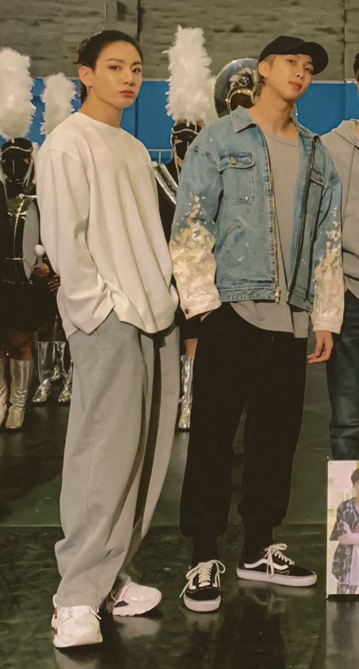 three young men standing next to each other in front of a poster with the same image on it