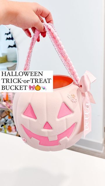 a hand holding a trick - or - treat bucket