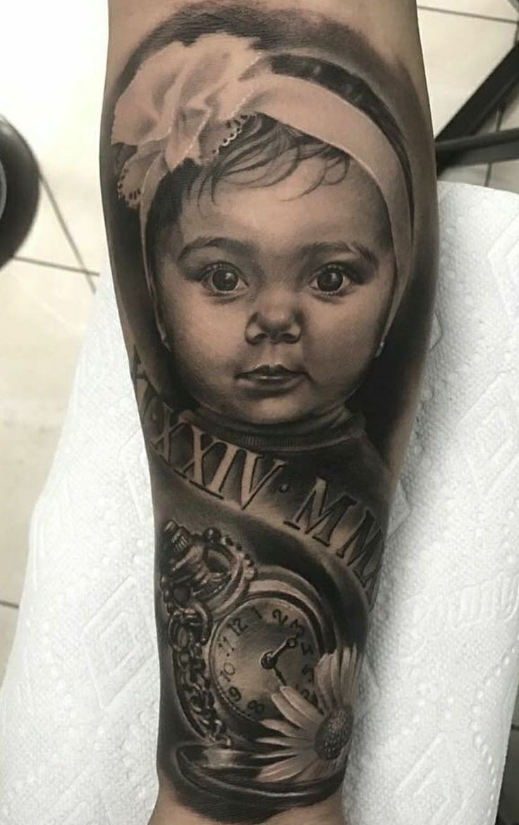 a person with a tattoo on their arm that has an image of a baby's face