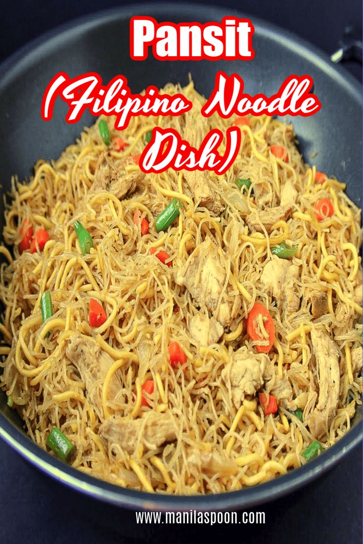 a pan filled with noodles and meat on top of a blue countertop next to a red sign that says pansit