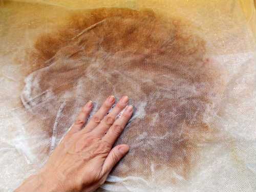 a person's hand on top of a piece of cloth