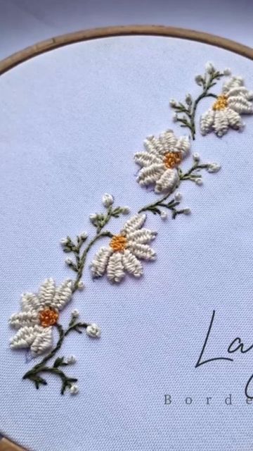 there is a cross stitch pattern with daisies on it