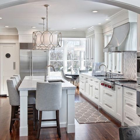 a large kitchen with white cabinets and stainless steel appliances