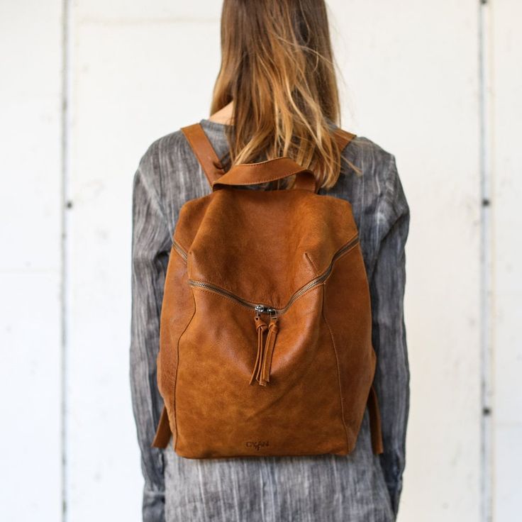 This super cool large and unique leather backpack a minimalist design with a clean, geometric cut. It offers a spacious, lined interior with two large compartments, a zipper pocket, and adjustable straps. The antique gold hardware adds a touch of elegance and modernity to the overall look. Features: *  1 Interior large zipped pocket * Outside zipper pocket in the back of the bag   * Fully lined with strong Black cotton * 2 departments * Adjustable shoulder strap * zipper closure  ◄ DIMENSIONS ► Leather Backpack Women, School Satchel, Women Backpack Travel, Leather Laptop Backpack, Brown Leather Backpack, Backpack Laptop, Leather Backpack Purse, Leather Rucksack, Women Leather Backpack