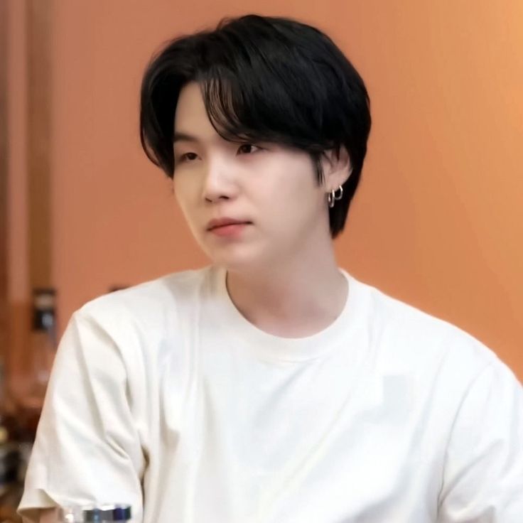 a young man with black hair sitting down