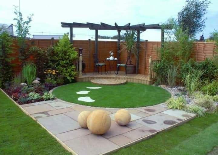 a small garden with grass and rocks in the middle