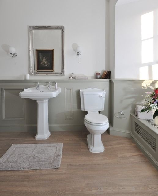 a white toilet sitting next to a sink in a bathroom