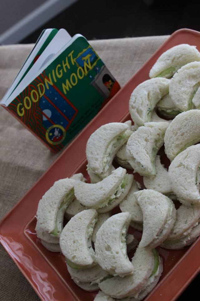 small sandwiches are arranged on a plate next to a book