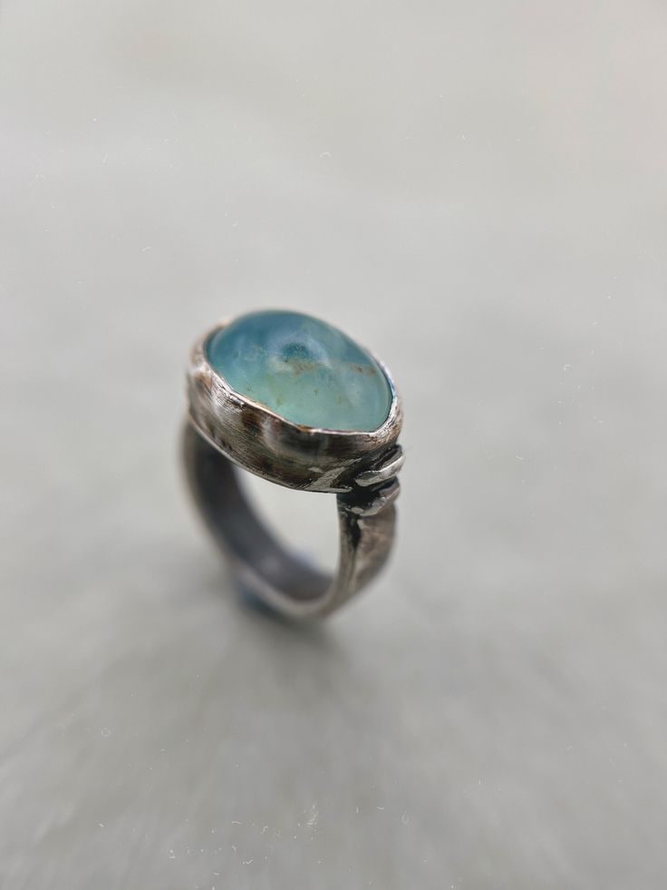 This listing is for a beautiful rare light aqua blue Andean Opal gem stone set into a chunky darkened sterling silver ring with a rustic finish for an earthy look. Opal is found and revered across the globe and can be found all over, from Canada to Ethiopia, Australia to Madagascar. But none are as rare and beautiful as the Andean Opals. These opals could only be found in Andean mountains in Peru.  Materials: Sterling silver 925 and fine silver 999, Andean blue Opal (Peru). Dimensions: Ring size Fine Jewelry Aquamarine Gemstone, Fine Aquamarine Gemstone Jewelry, Fine Jewelry Aquamarine Gemstone Jewelry, Round Aquamarine Gemstone Jewelry, Oval Aquamarine Fine Jewelry, Sapphire Jewelry With Large Stone For Anniversary, Aquamarine Gemstone Jewelry For Jewelry Making, Oval Aquamarine Turquoise Ring, Oval Aquamarine Rings In Turquoise Color