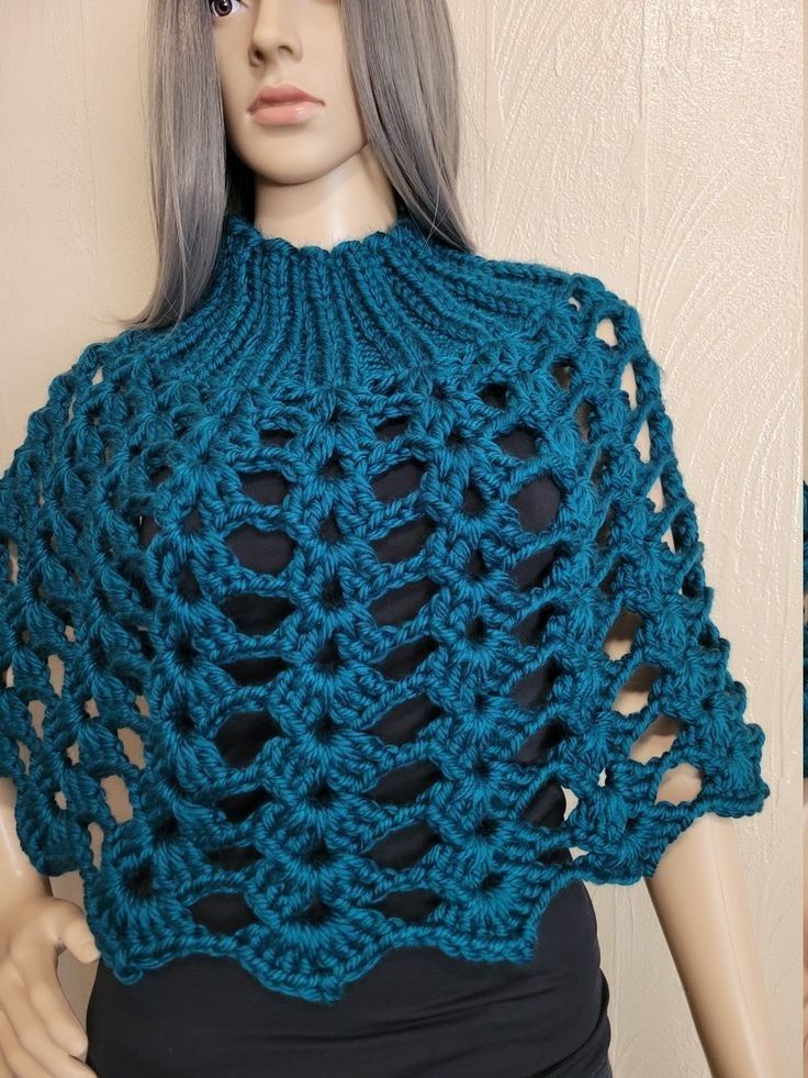 a mannequin wearing a blue crocheted shawl