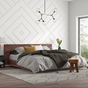 a bedroom with white walls and wood furniture