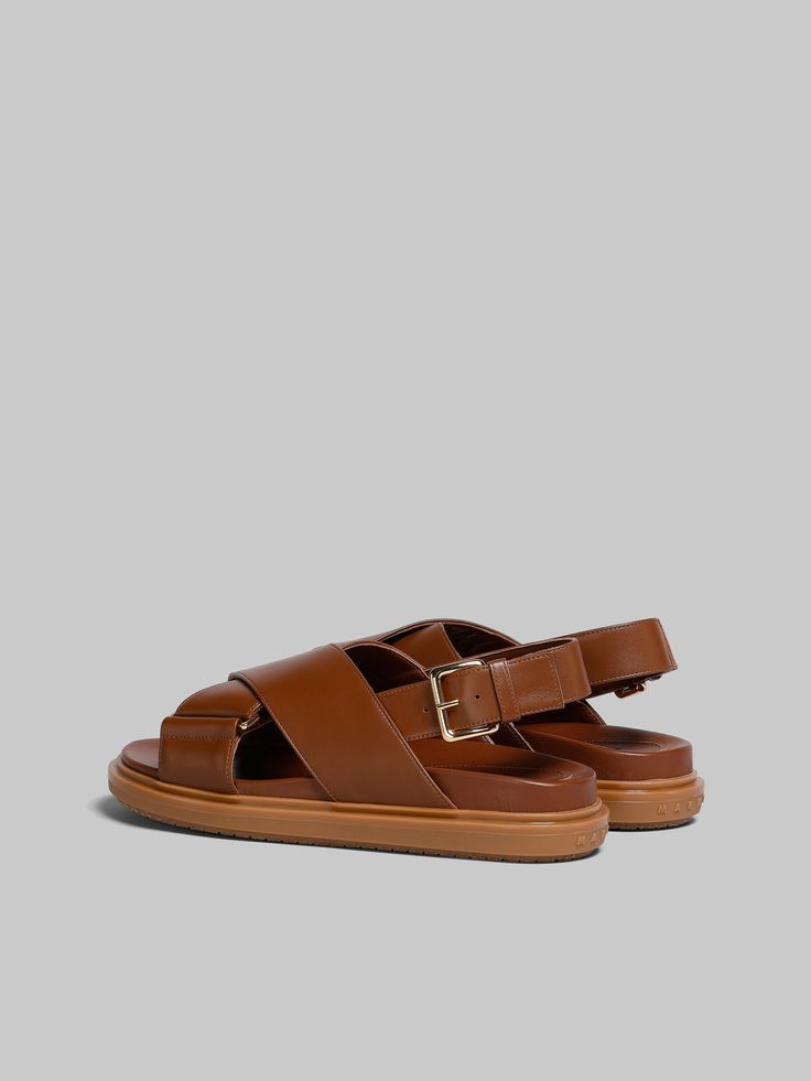 Iconic crisscross Fussbett sandal crafted from smooth calfskin leather, fastening with an adjustable buckle strap. Monocolour design with tonal leather insole and rubber outsole. Raised Marni lettering on the heel. Marni Sandals, Slides Sandals, Slides Shoes, Criss Cross, Calf Leather, Calf Skin, Brown Leather, Womens Sandals, Buckle