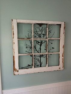 an old window is decorated with branches in the shape of a tree and birds on it