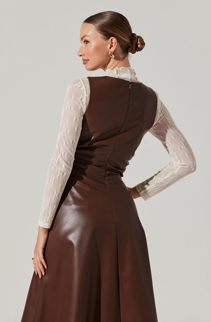 a woman is wearing a brown leather dress