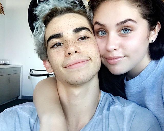 a young man and woman are posing for a selfie in front of the camera