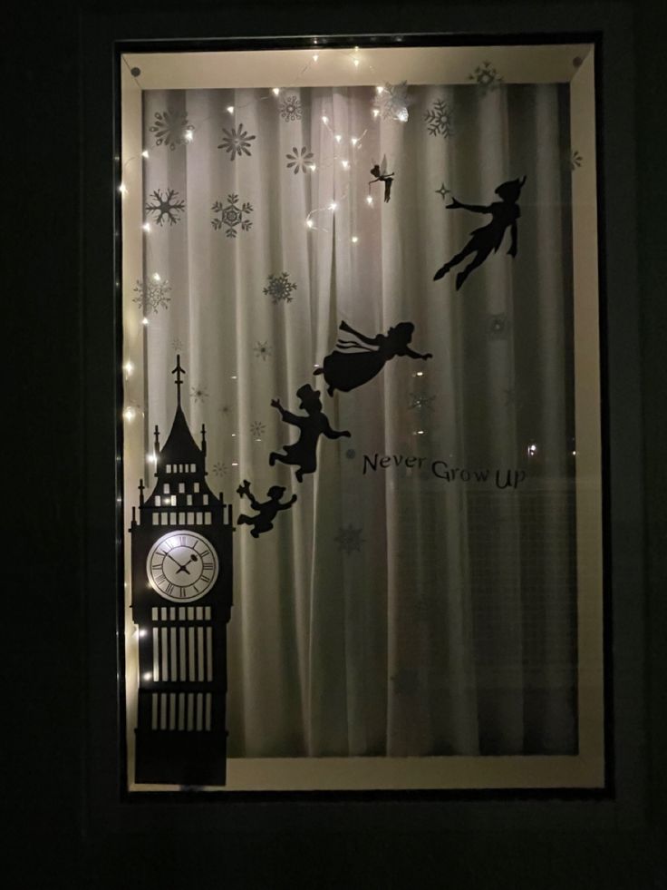 the window is decorated with fairy silhouettes and lights