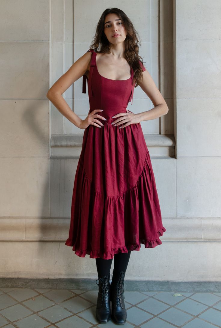 ready to ship xx a truly special dress. with rich ribbon tie straps, a corset bodice, and sweeping ruffle hem the mirabelle dress is dramatic, romantic beauty at its best and one of our most popular styles. updated in a beautiful, show stopping burgundy red and made in a lightweight linen with a sateen finish that gives the linen a subtle dressy luster. a showstopper of a dress made for holiday gatherings, celebrations, or romantic getaways. details: pockets, of course! lined bodice with boning, Princess Dresses Casual, Red Christmas Gown, Christmas Wedding Guest Dress, Corset Dress Aesthetic, Dress For Rectangle Body Shape, Red Dress With Corset, Bookish Costumes, Big Red Dress, Graduation Dress Red