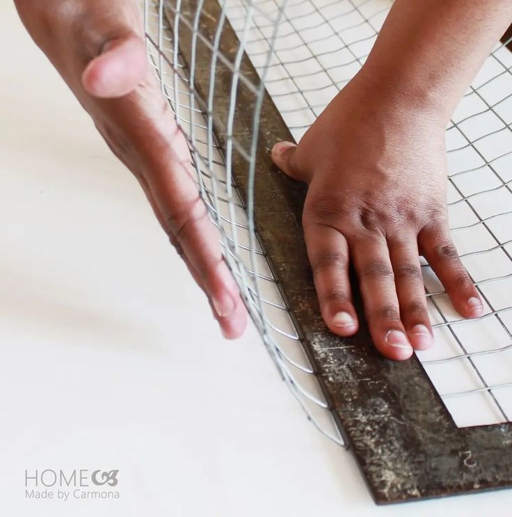 a person reaching for something on top of a tile floor with their hands over the grate