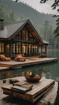 a wooden dock sitting next to a lake with a house on it's side