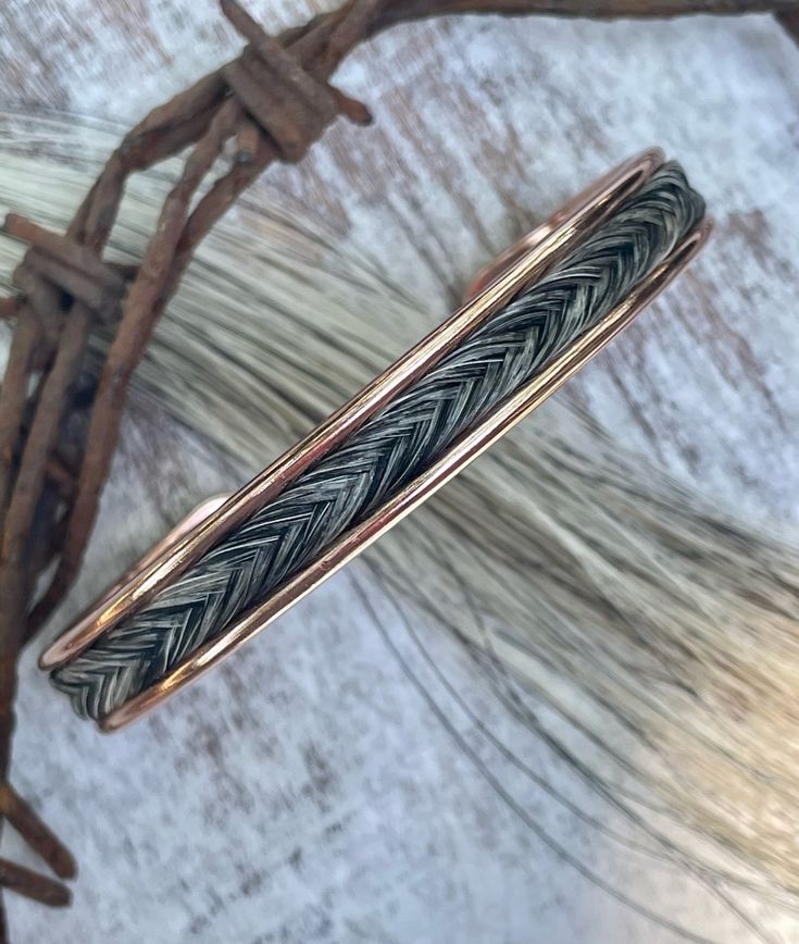 a close up of a ring on top of a wooden table with branches in the background