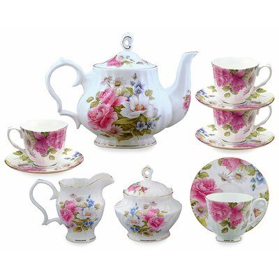 a tea set with pink flowers on it and saucers, cups and saucers