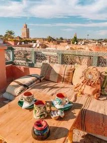 a wooden table sitting on top of a roof next to a couch and coffee cup