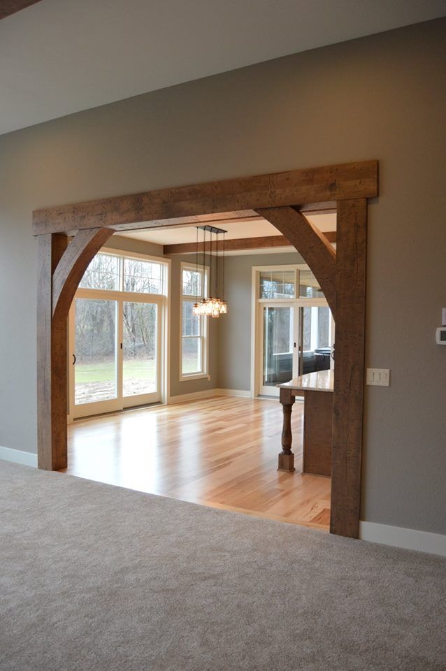 an empty living room with wooden beams and windows