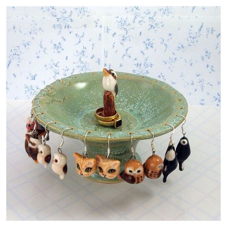 a birdbath with several key chains hanging from it's sides and cats on the bottom