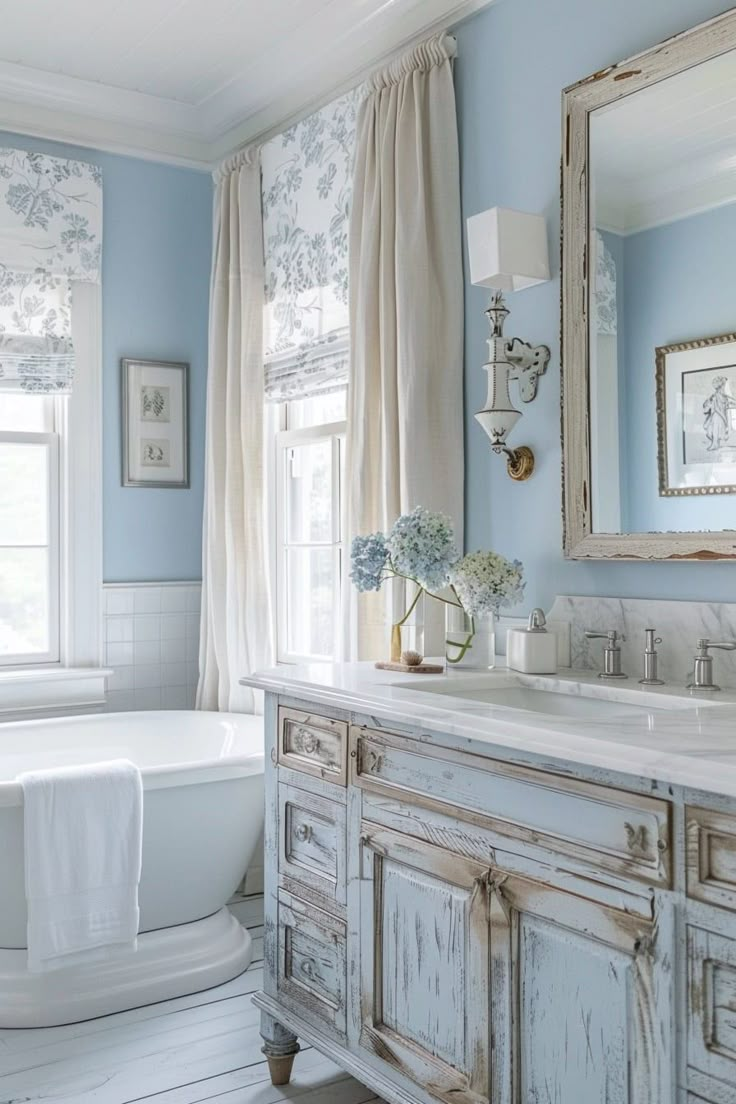 a bathroom with blue walls and white fixtures, including a claw foot tub in the center