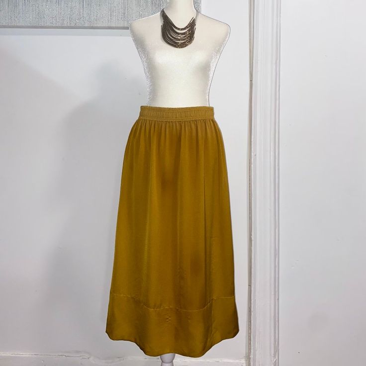 Dark Yellow Knee-Length Skirt In Satin With A High Waist, Elasticized Waistband, And Side-Seam Functional Pockets. Unlined And Never Worn. Has Some Threading Pulls As Pictured. 100% Polyester. Necklace Not Included. Chic Yellow Skirt With Elastic Waistband, Elegant Yellow Skirted Bottoms, Yellow Stretch Maxi Skirt For Spring, Yellow Skirted Bottoms With Elastic Waistband, Gold Long Skirt For Summer, Elegant Long Yellow Skirt, Gold Relaxed Skirt Bottoms For Spring, Gold Relaxed Fit Skirt For Spring, H&m Stretch Skirt For Spring