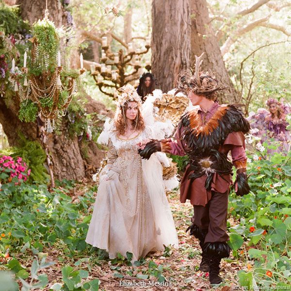 two people dressed up in costumes walking through the woods