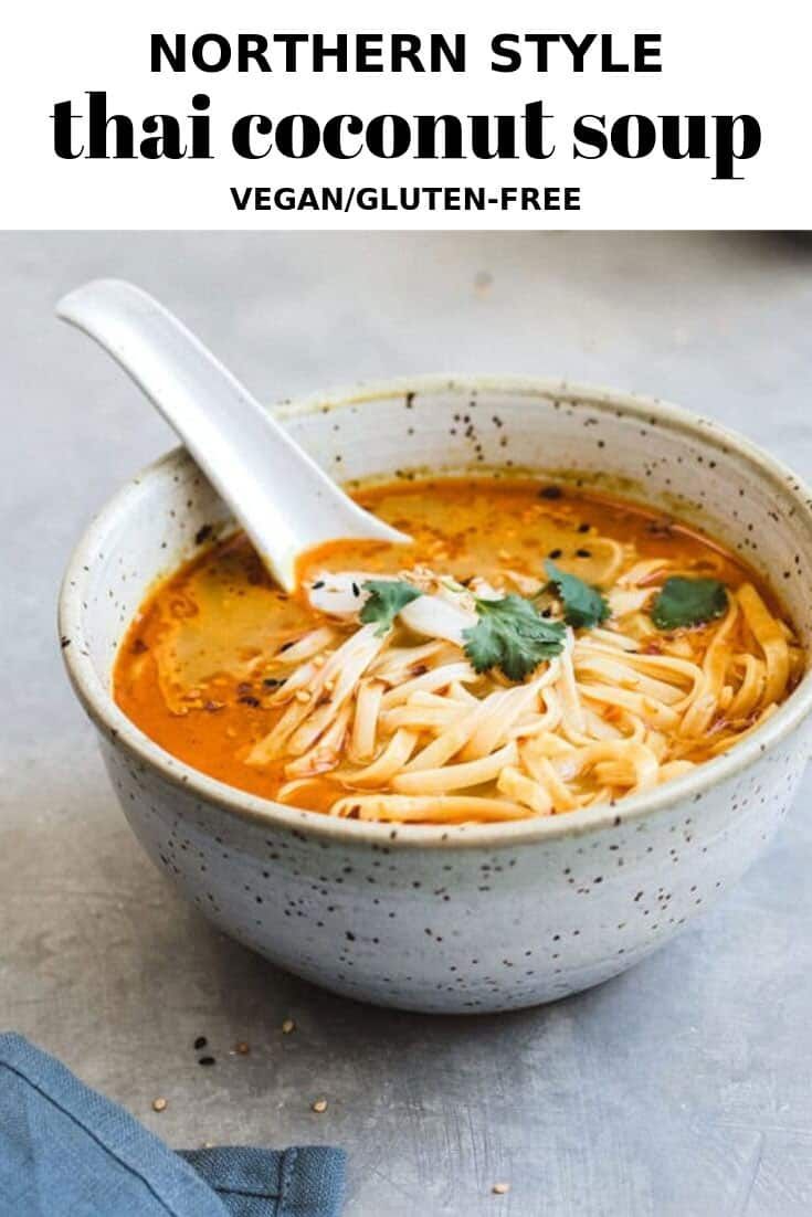 a white bowl filled with noodles and garnished with parsley