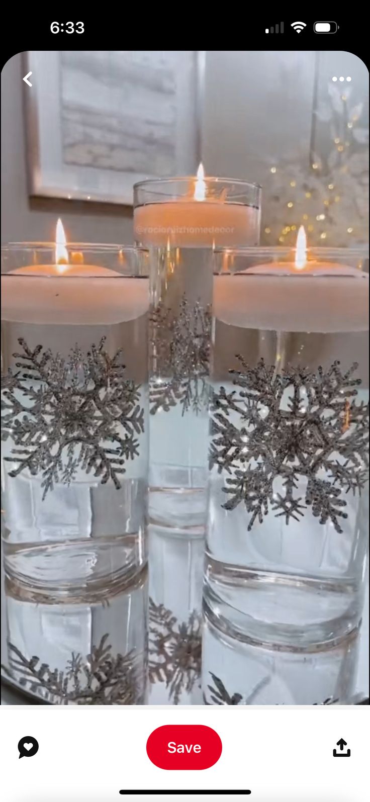 some candles are in glass containers with snowflakes on the inside and around them