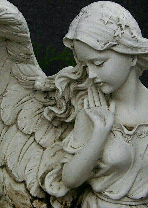 an angel statue with her hands to her face