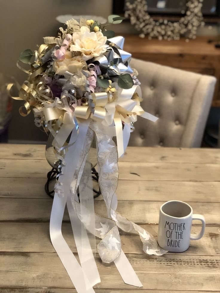 a bouquet of flowers sitting on top of a wooden table next to a coffee cup