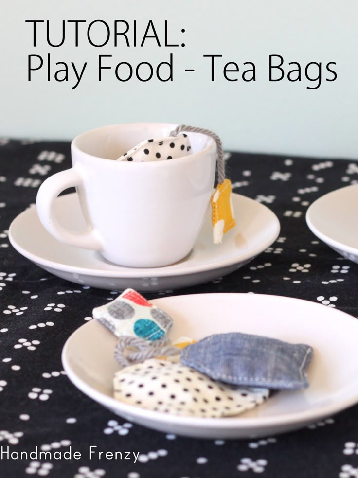 two plates with tea bags on them sitting on a table next to a cup and saucer