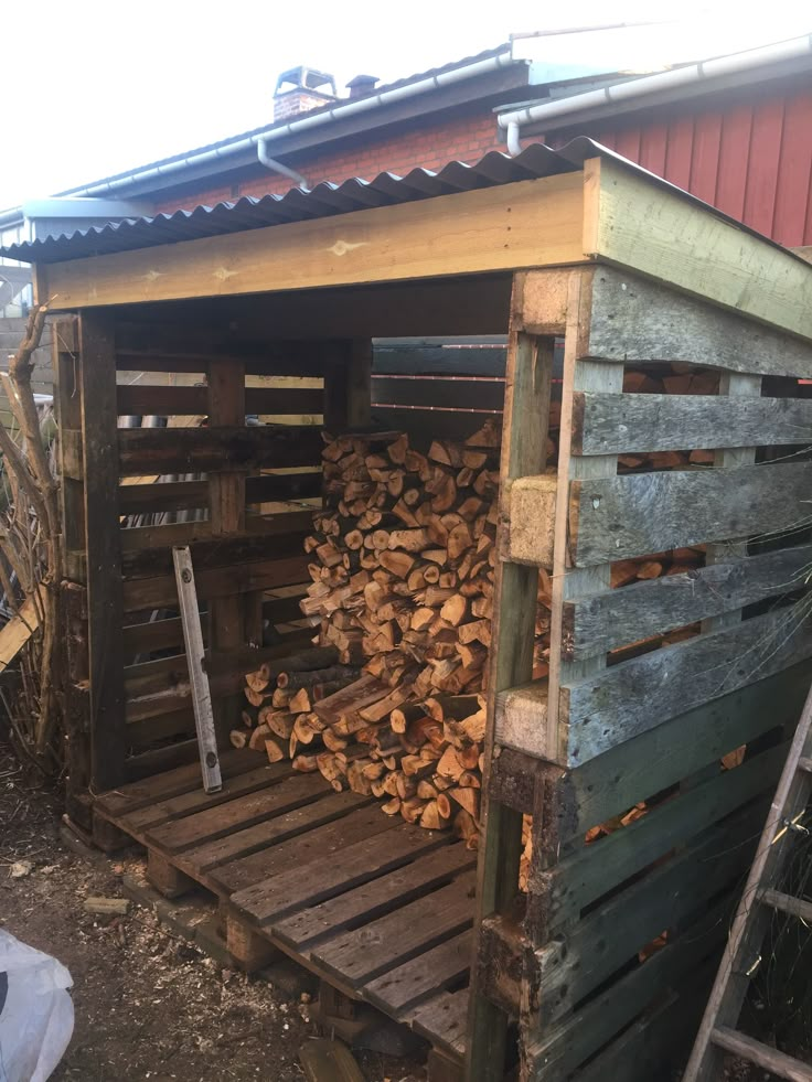 a pile of wood sitting inside of a wooden shed