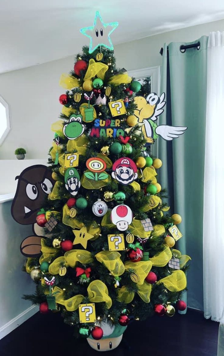 a decorated christmas tree in the corner of a room with mario bros decorations on it