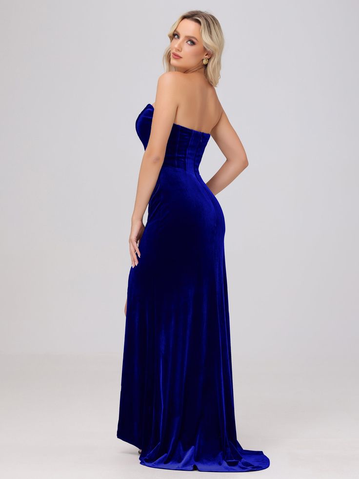 a woman in a blue velvet gown with one shoulder and open back, looking at the camera