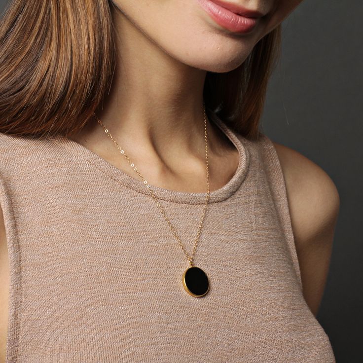 "Black onyx drop necklace on 14k dainty gold filled chain - Jewelry gifts for Her - Black and gold jewelry - Minimalist necklaces - Black Stone: Genuine black onyx Stone: 20mm diameter Gold chain: 14k gold filled Chain length: 18 inches Clasp: spring ring Arrives in gift box Made in the USA About \"Gold Filled Jewelry\": Also called rolled-gold. These jewelry items are not actually filled with gold. They are made of a base metal covered by sheets of gold in a mechanical bonding process. Effectiv Elegant Black Necklace With Cable Chain, Minimalist Black Cable Chain Necklace, Elegant Black Jewelry With Cable Chain, Gold Round Necklace With Black Enamel, Black Round Pendant Necklace, Gold Plated, Black Round Pendant Necklace In Gold Plated, Black Gold Plated Round Pendant Necklace, Minimalist 14k Gold-filled Pendant Charm Necklace, Minimalist 14k Gold Filled Pendant Chain Necklace