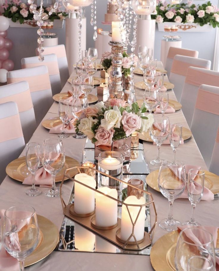 a table set with candles, plates and flowers for a formal dinner or wedding reception