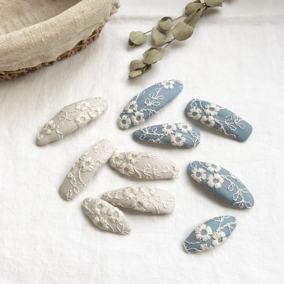 several white and blue decorated nail tips next to a basket with flowers on it's sides