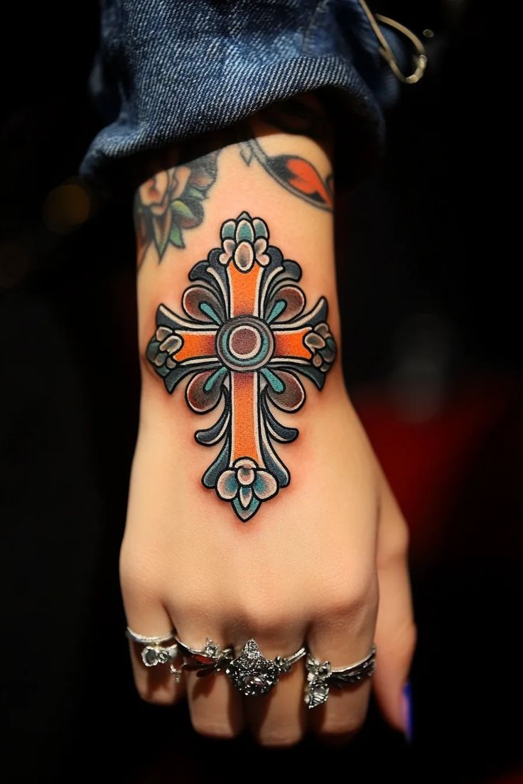 a woman's hand with a cross tattoo on it