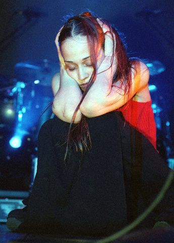 a woman sitting on the ground with her hands behind her head