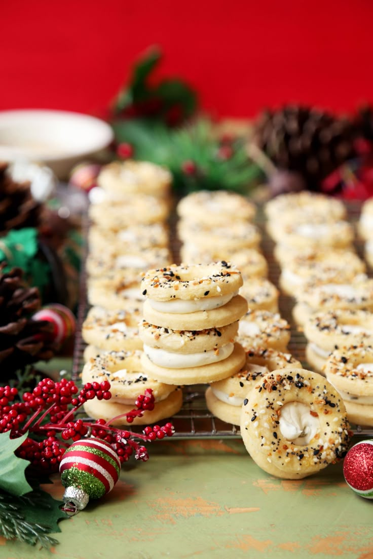 cookies are arranged on a cooling rack with christmas decorations around them and pine cones in the background