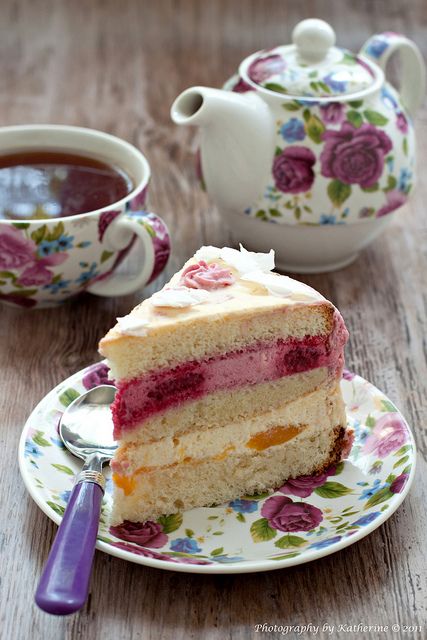 a piece of cake on a plate next to a cup of tea