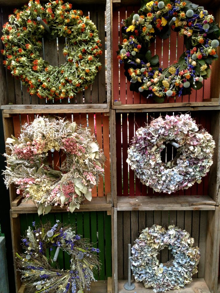 several wreaths are arranged on wooden shelves