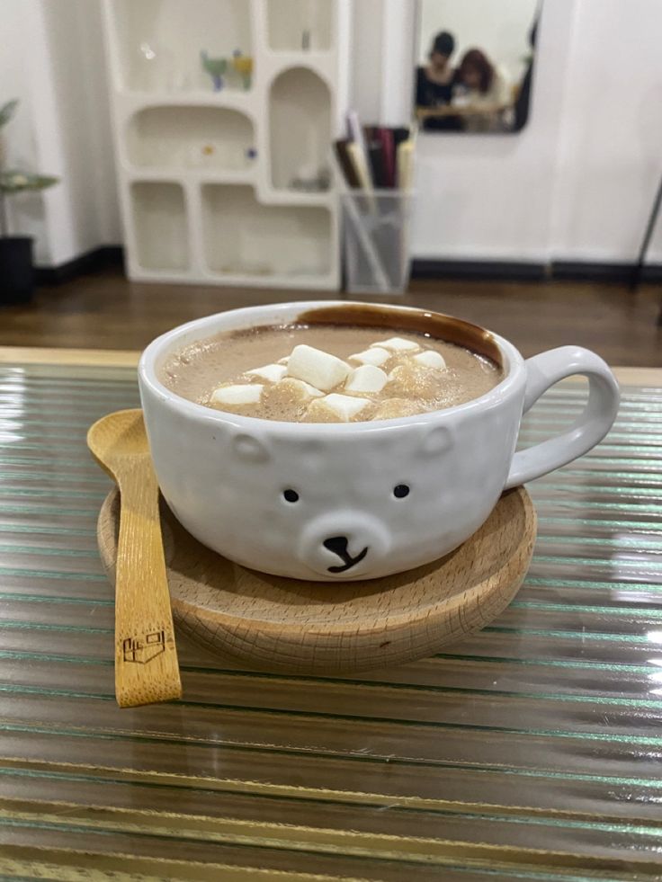 a cup of hot chocolate with marshmallows in the shape of a bear