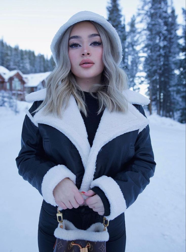 a woman standing in the snow with her hand on her hip