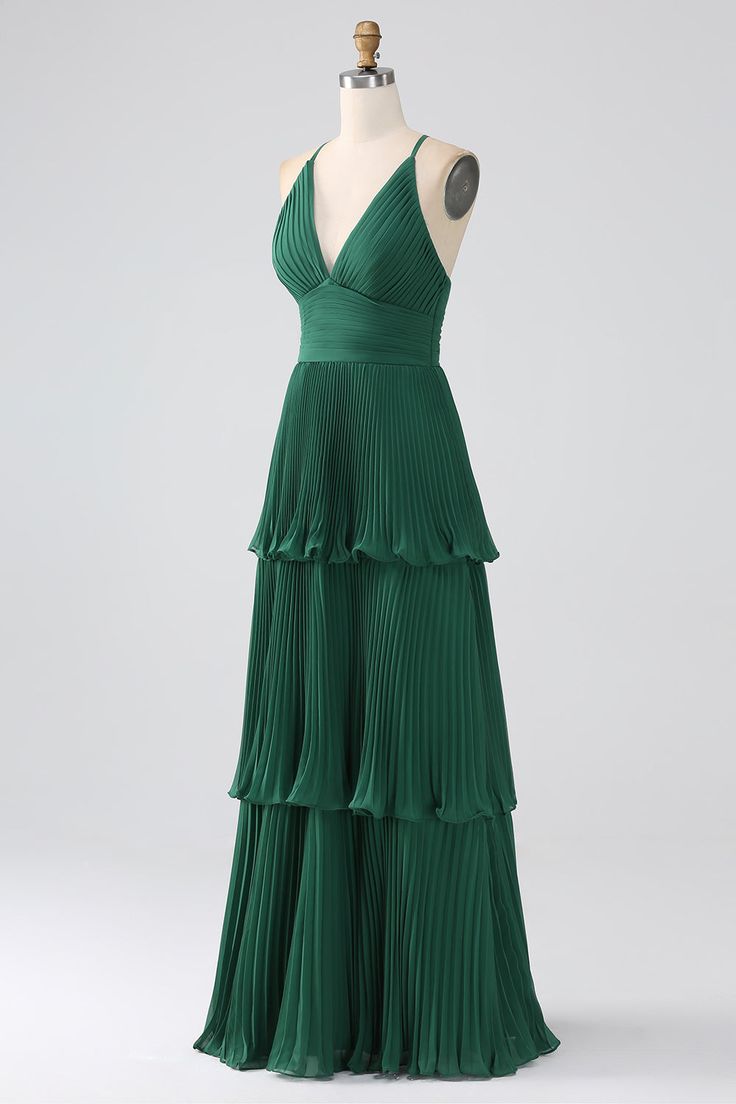 a green dress on a mannequin with pleated skirt and v - neck